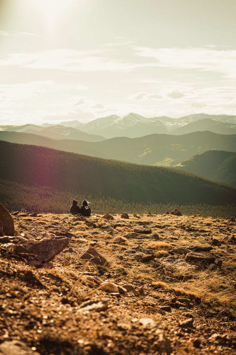 a couple staring off into the distance of hills and mountains