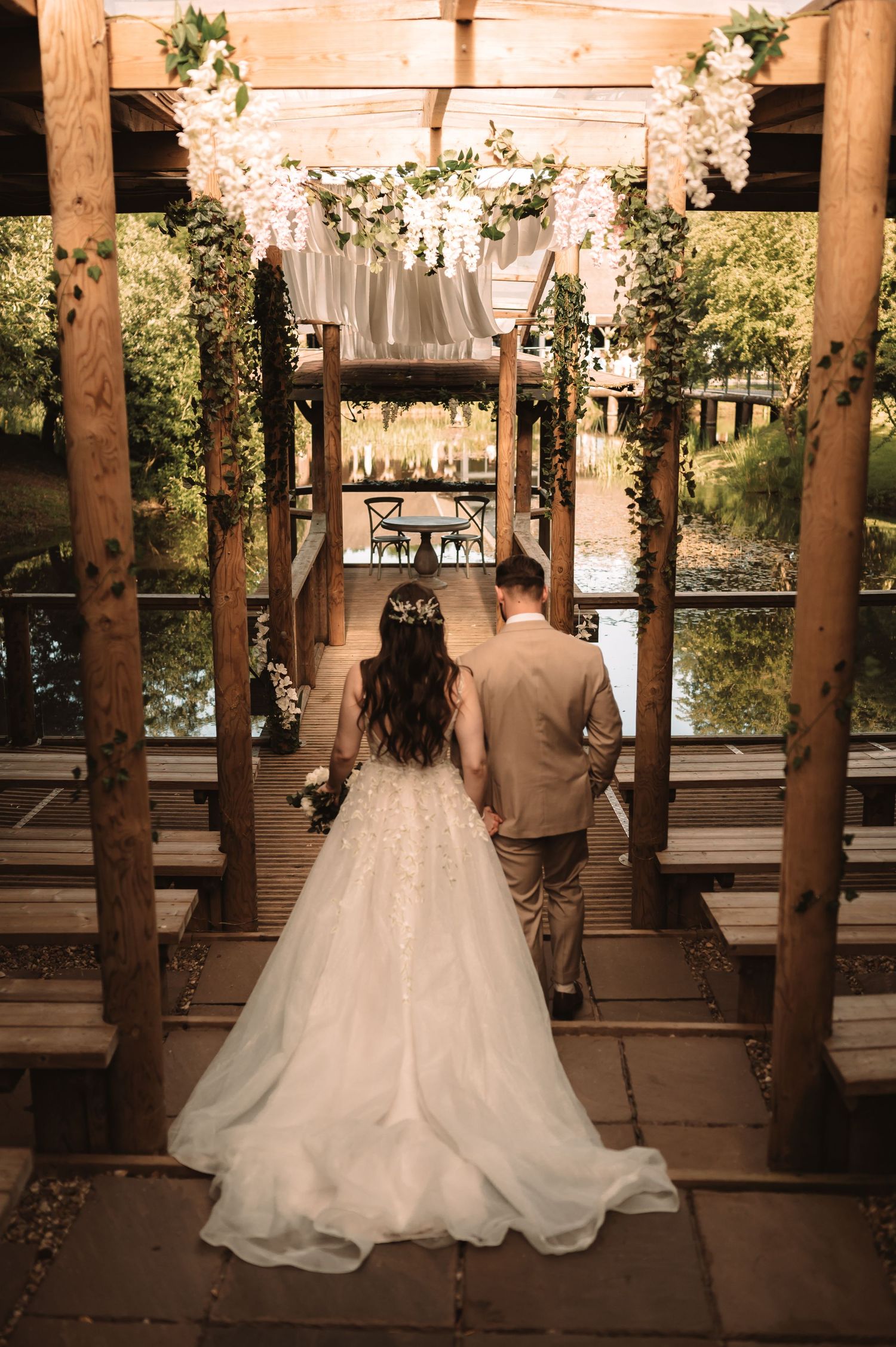 Wedding ceremony setup with floral decorations and wooden beams overlooking a scenic view.