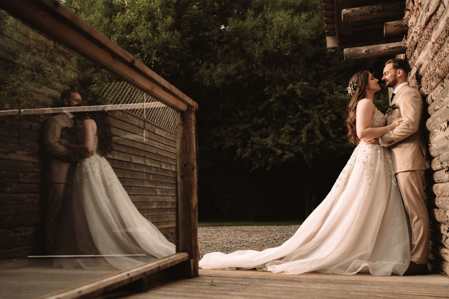 Elegant wedding dress train reflects in mirror on rustic wooden deck.