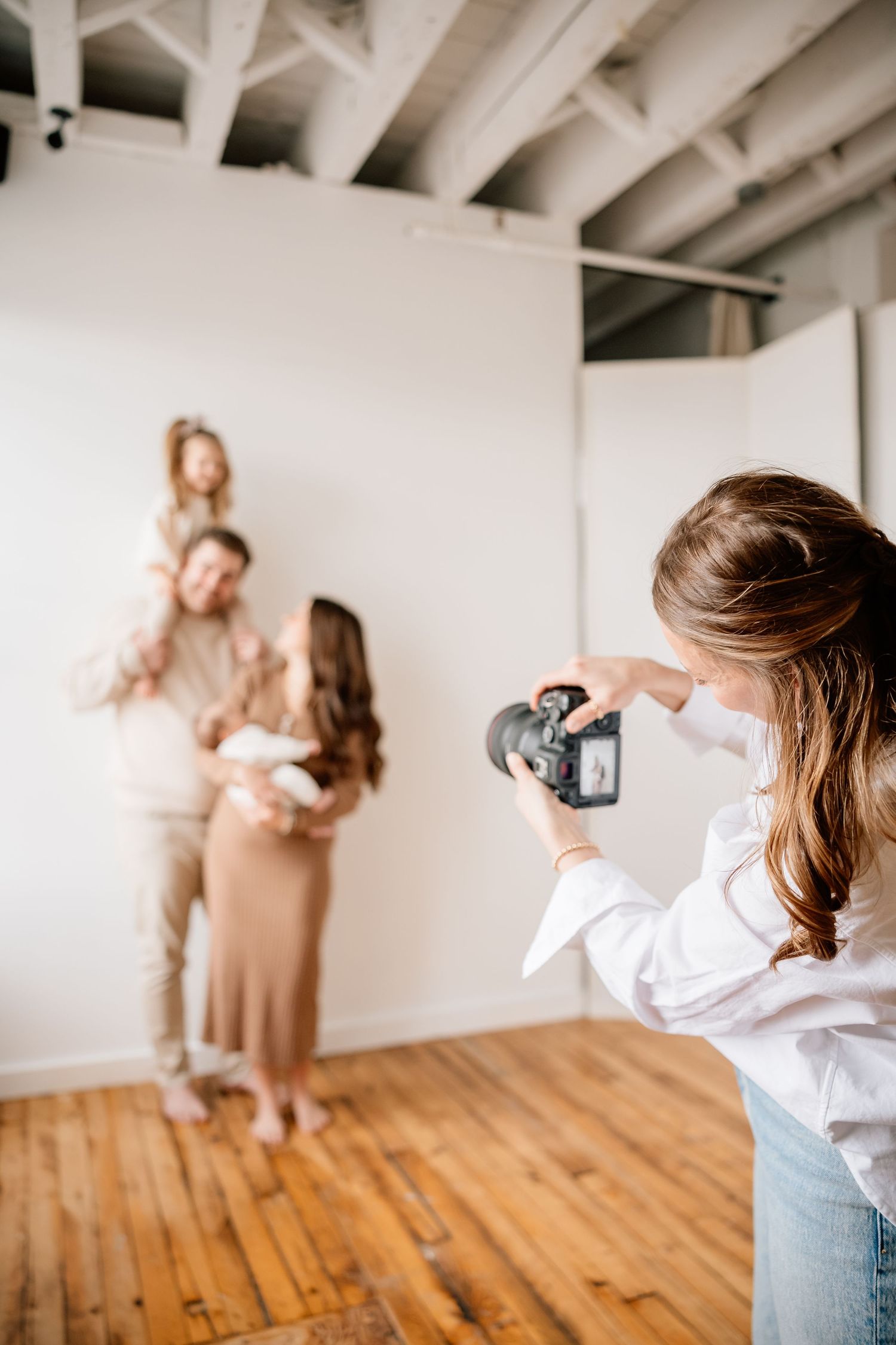 A sequence of photos showing someone taking pictures with a camera in a bright studio space with wooden floors.