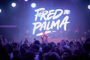 Crowded concert venue with 'Fred Palma' text displayed above enthusiastic audience.