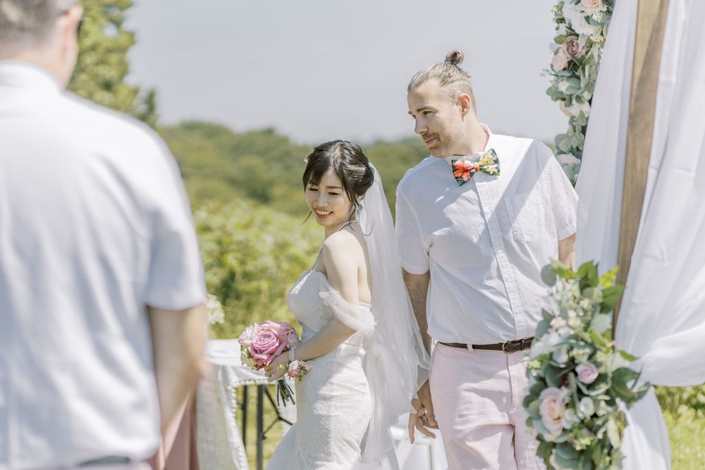 Wedding ceremony participants arranged in formation during outdoor summer celebration.