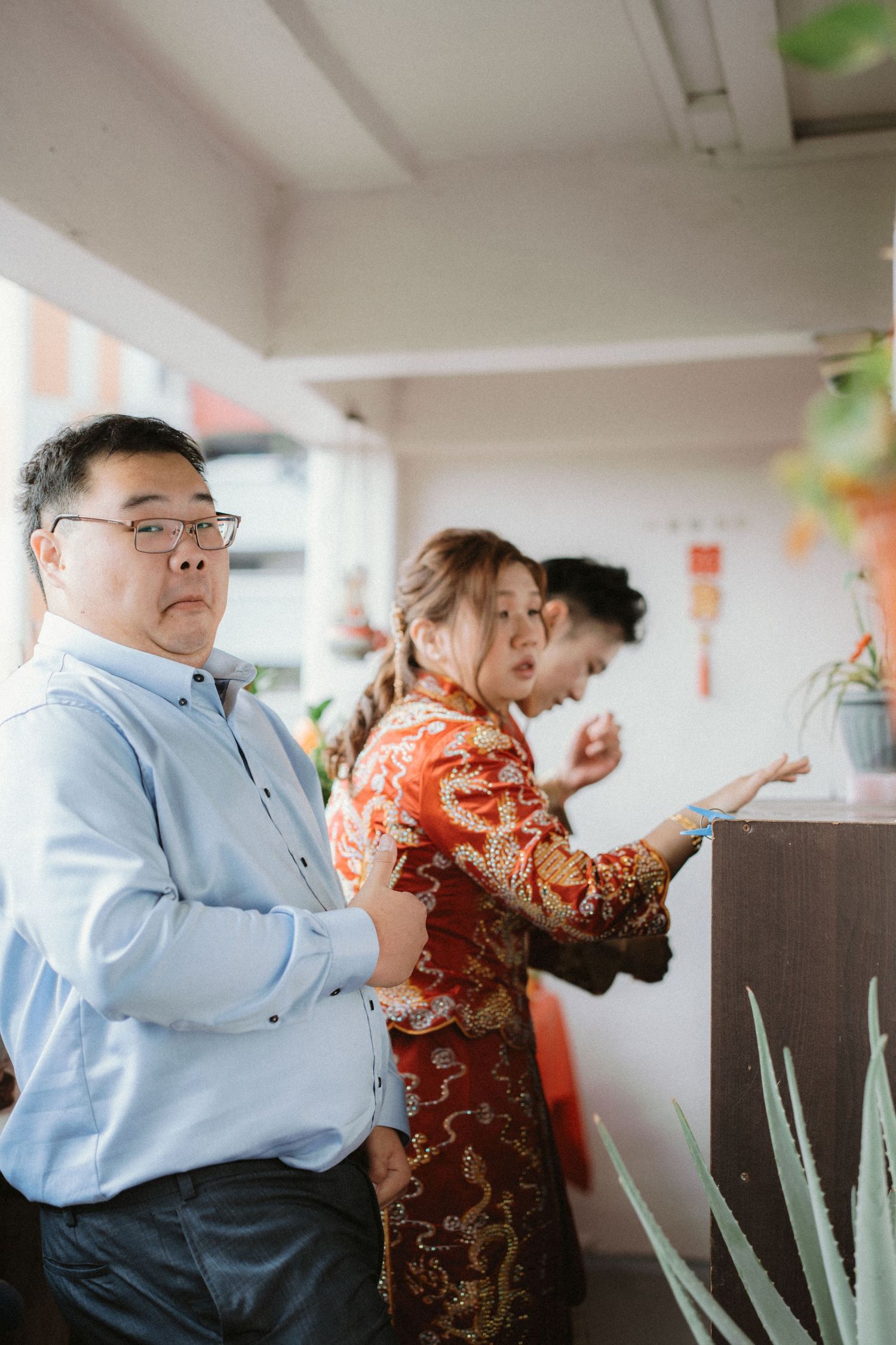People in formal attire gathered at an indoor event with traditional Chinese decorations.