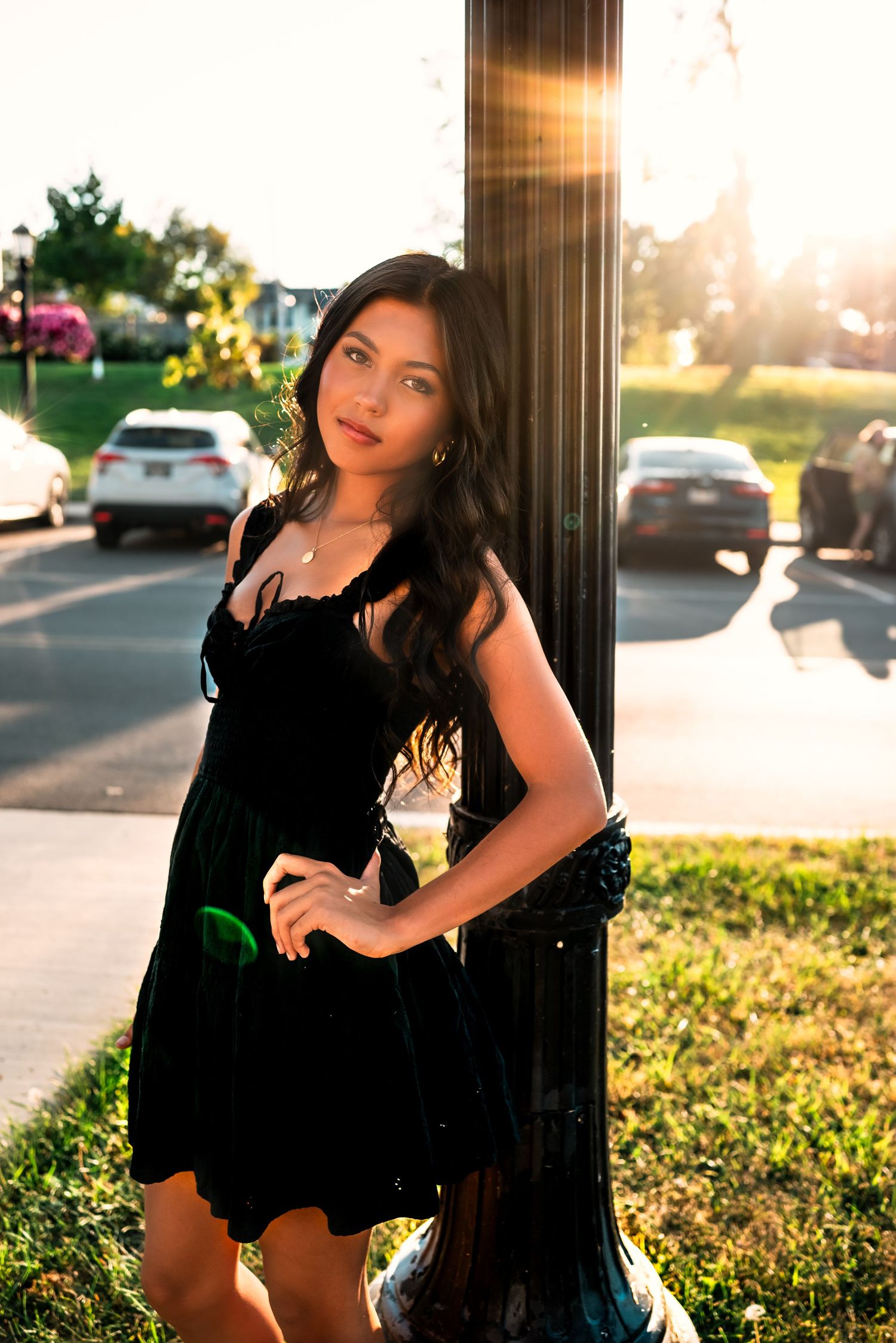 Artistic portrait series of someone in a black dress posing against a column during golden hour sunset.