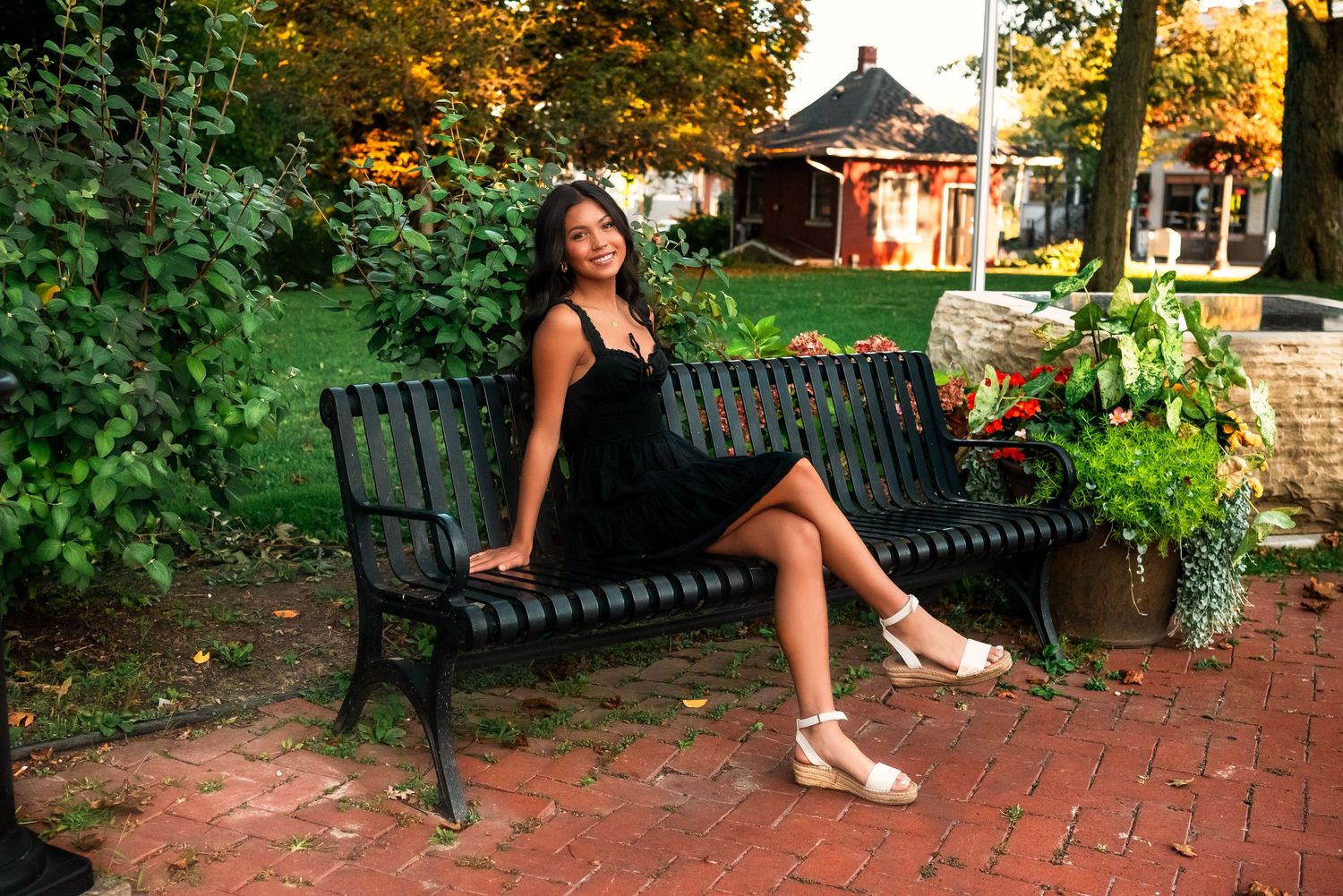 A series of connected photos showing someone sitting on a black metal bench in a garden setting at sunset.