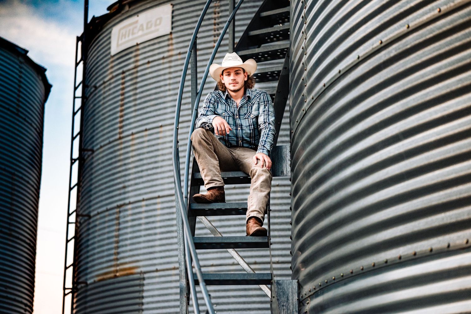 Artistic shots against curved metal grain silo in rural setting.