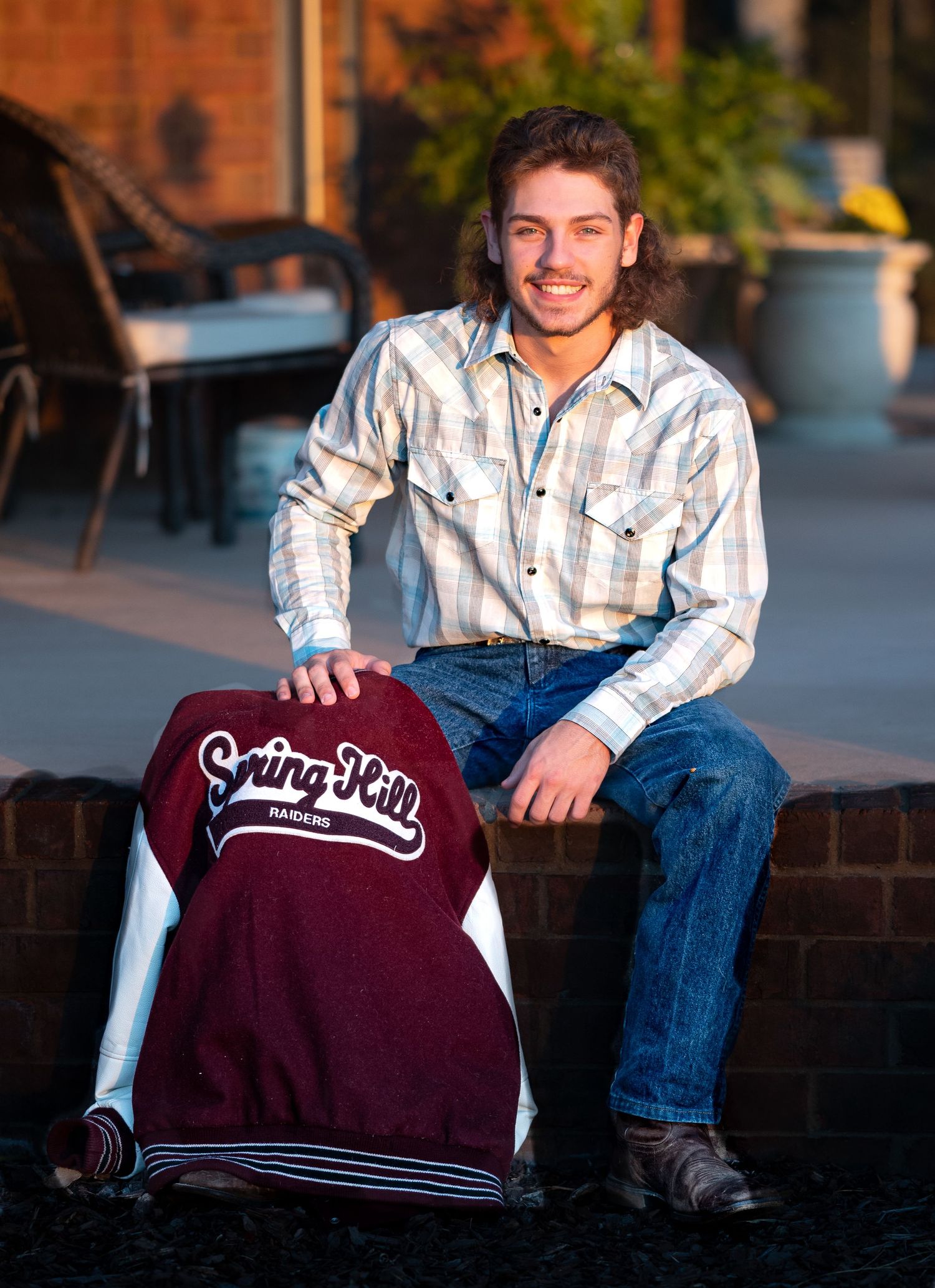 Casual outdoor portrait session featuring maroon university sweatshirt and denim.