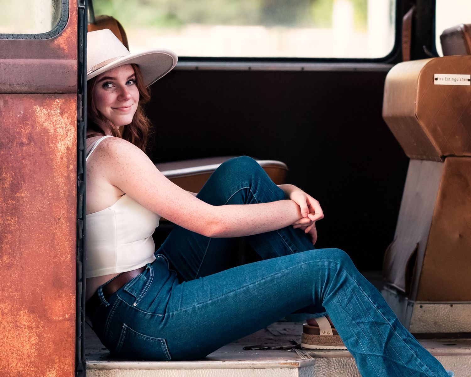 Casual portrait session inside vintage vehicle with natural lighting.