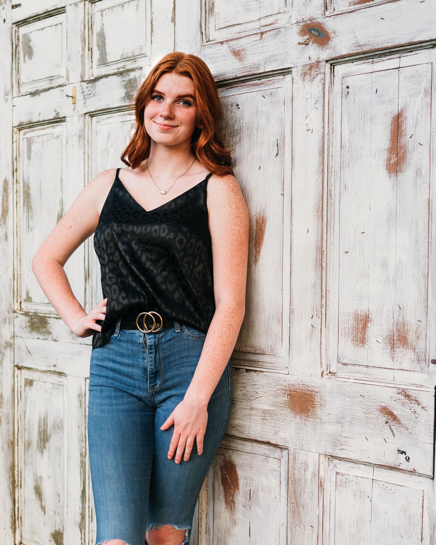 Fashion portrait against weathered white wooden door background.