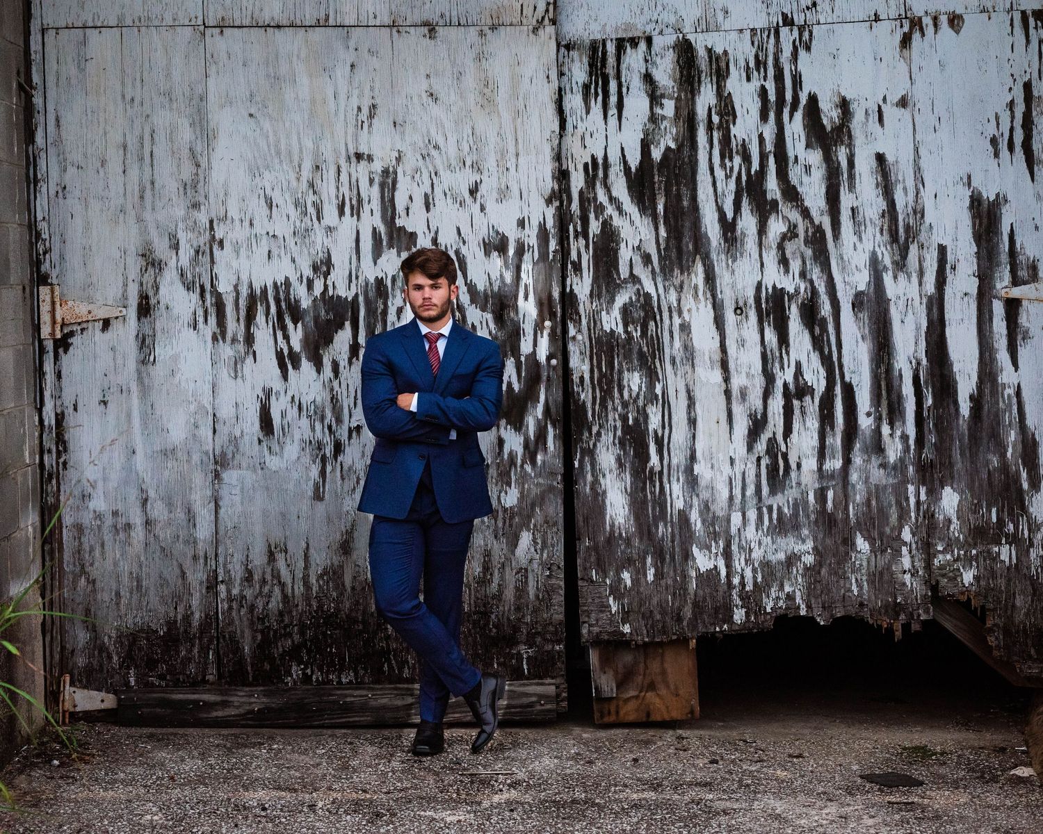 Fashion photoshoot against weathered industrial wall showing different poses.