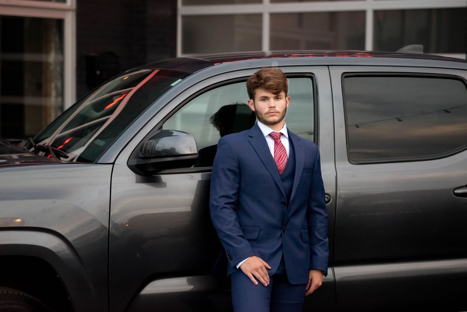 Fashion portraits with dark cars and formal attire in urban setting.