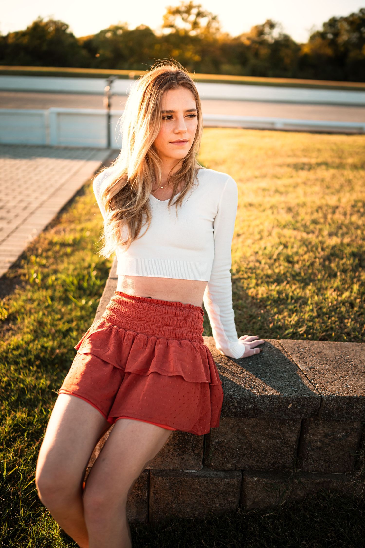 A sunset portrait session featuring a white top and red shorts against golden light.