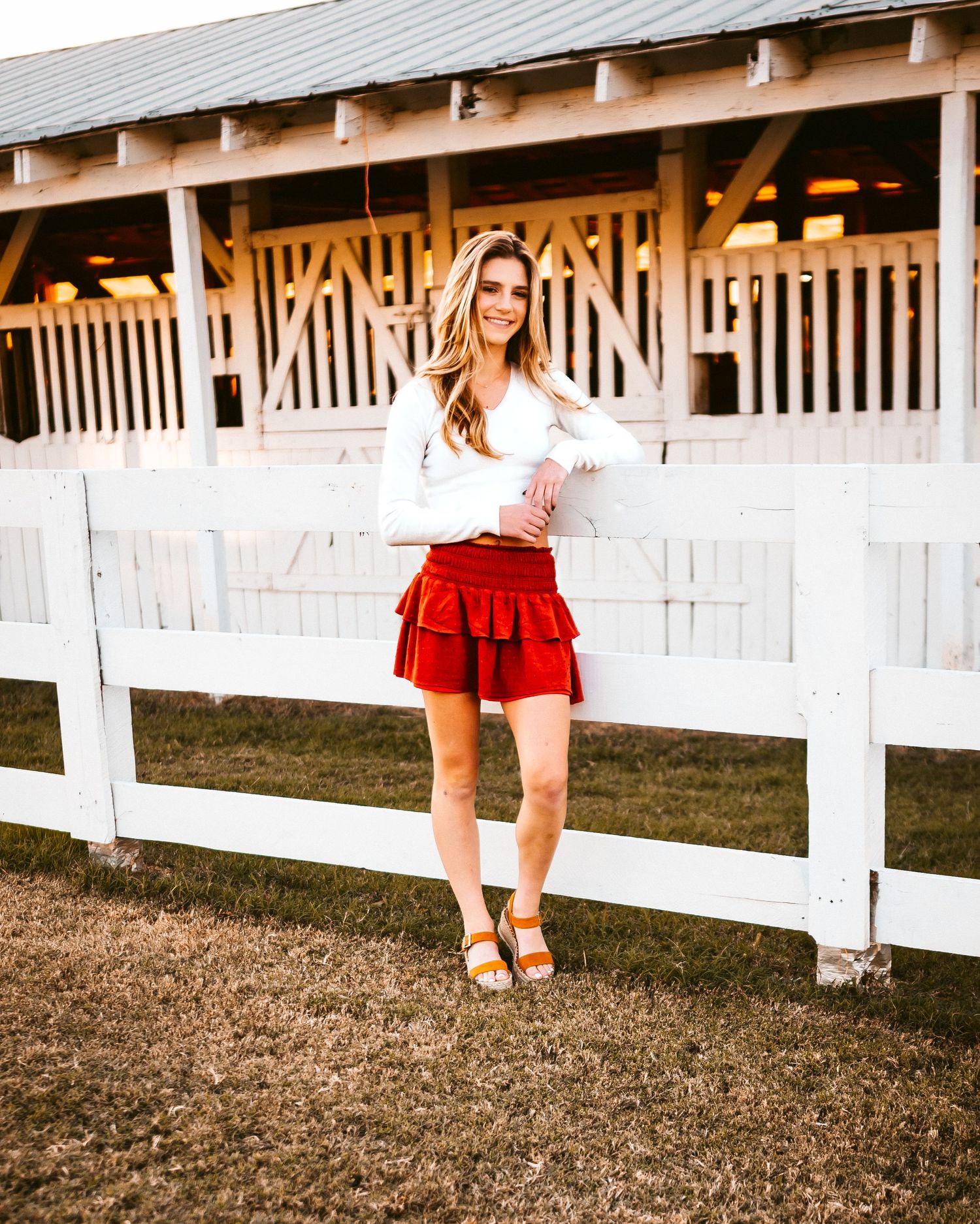 White picket fence and red clothing details in a rustic outdoor setting.