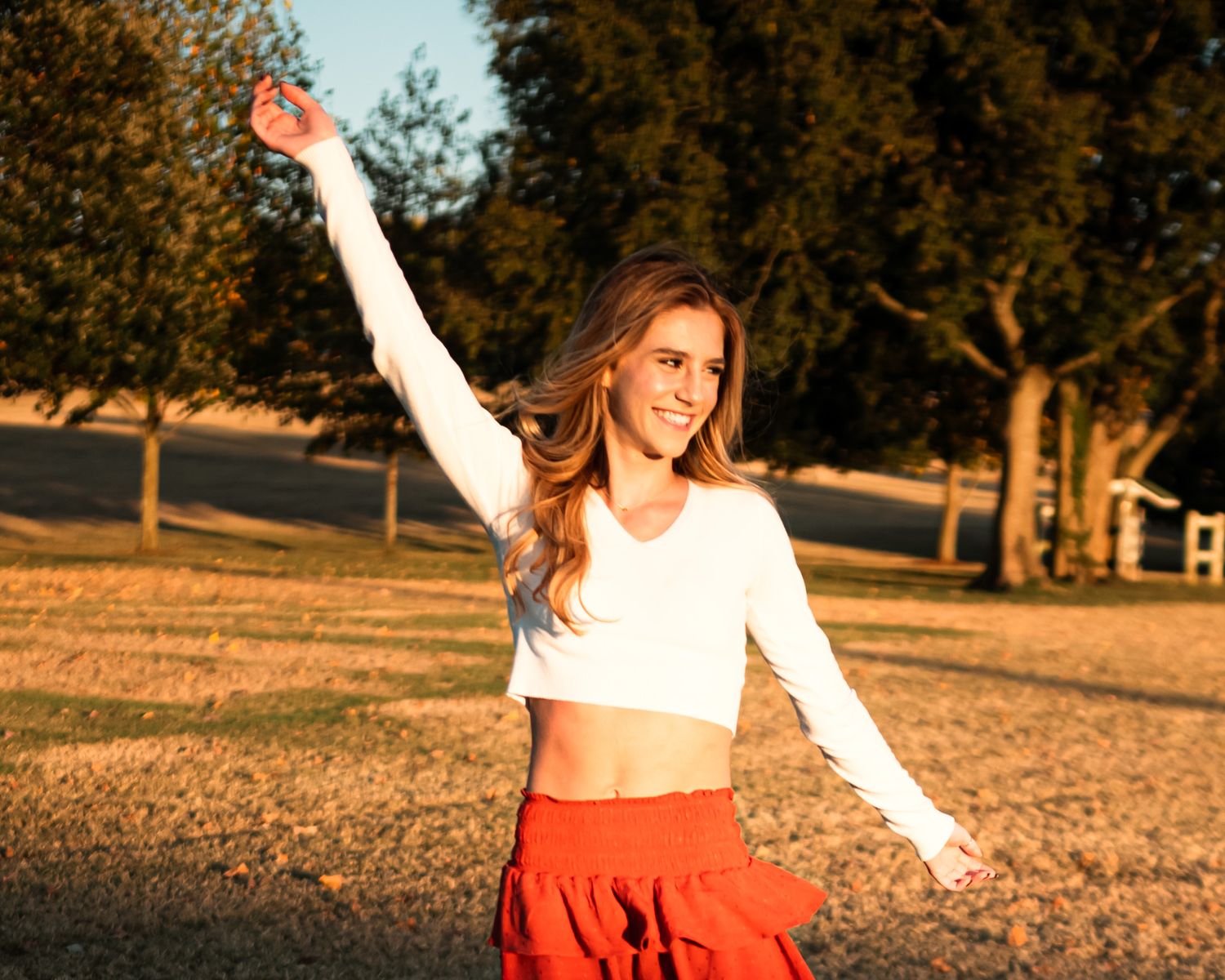 A playful outdoor photoshoot at sunset in a park setting.