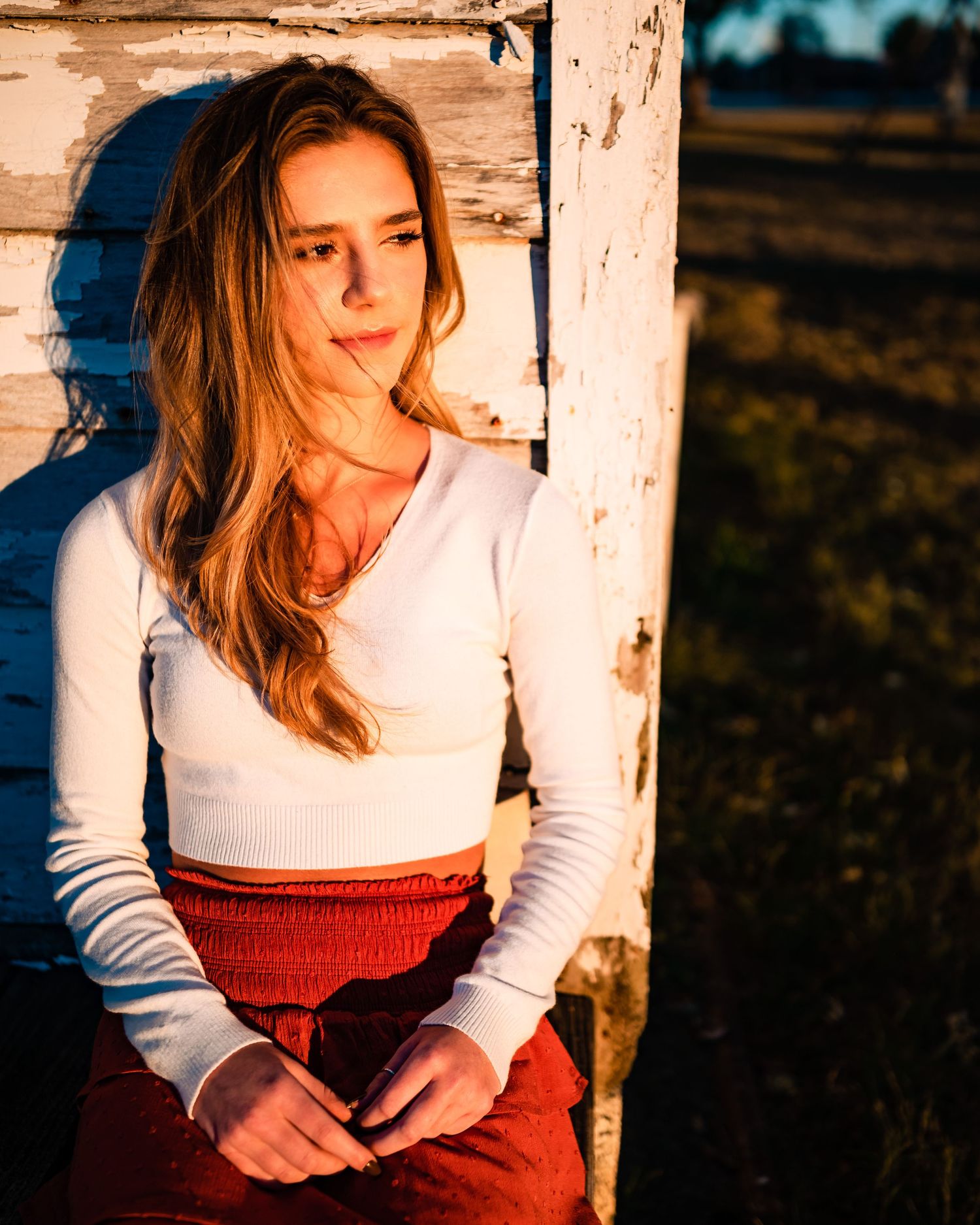 Sunset portrait against weathered wood with dramatic lighting.