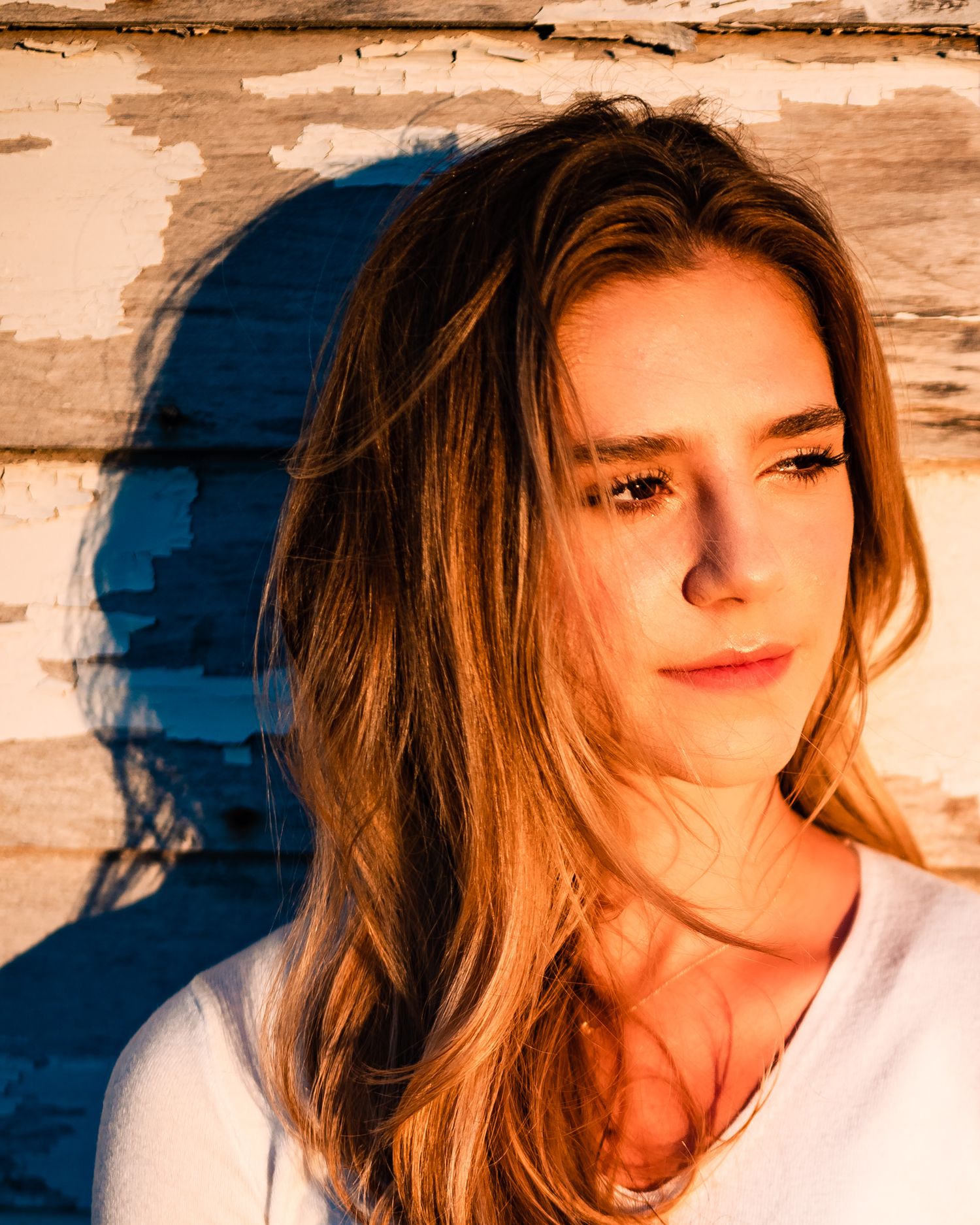 Artistic portrait with dramatic shadows and warm lighting.