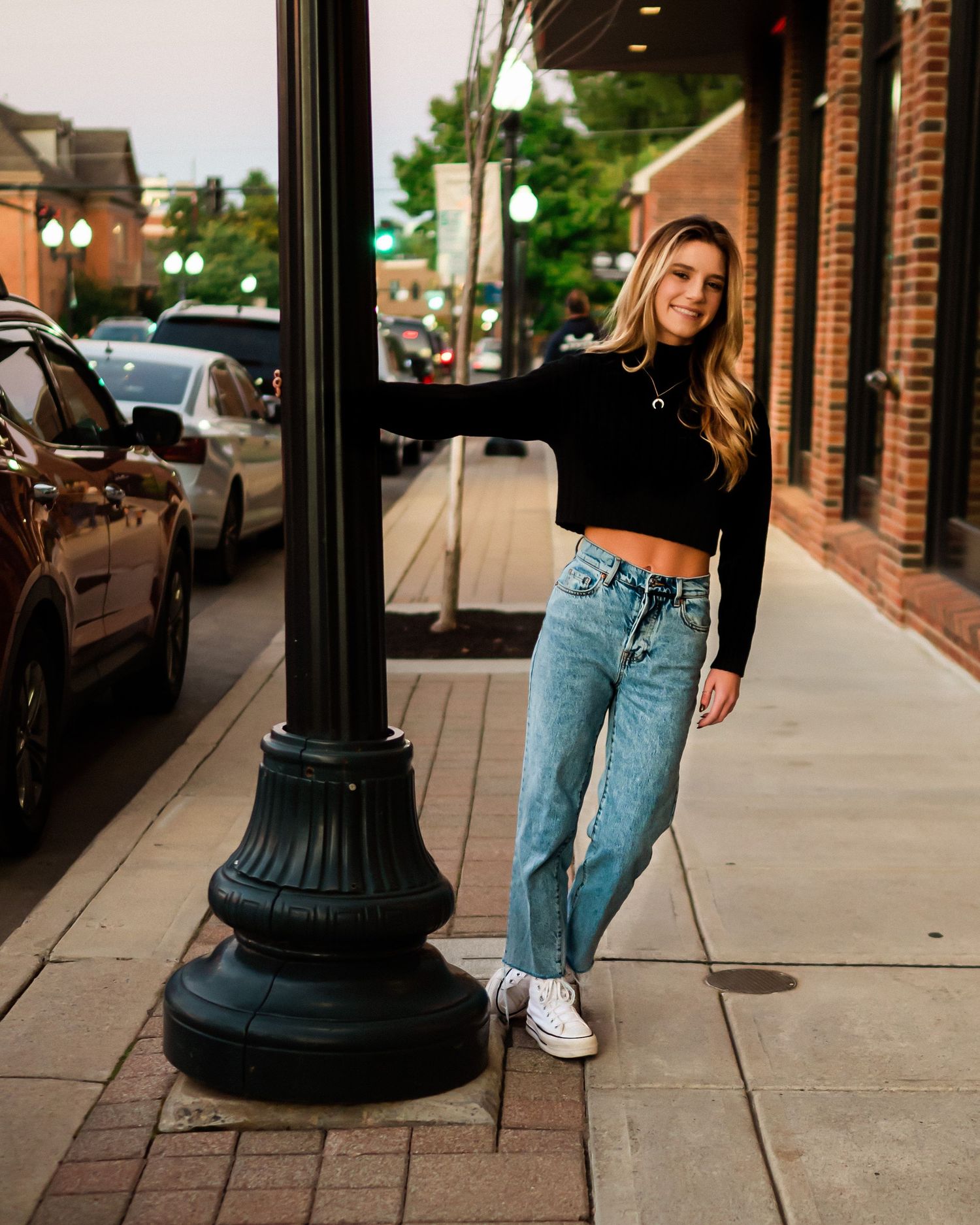 Street fashion photography featuring vintage lamp posts and brick architecture.