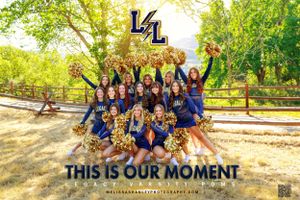 Cheerleading squad in blue uniforms poses enthusiastically outdoors with 'This is Our Moment' text.