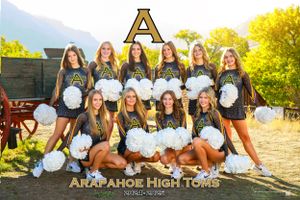 Arapahoe High cheer team poses in navy uniforms with white pom poms for group photo.