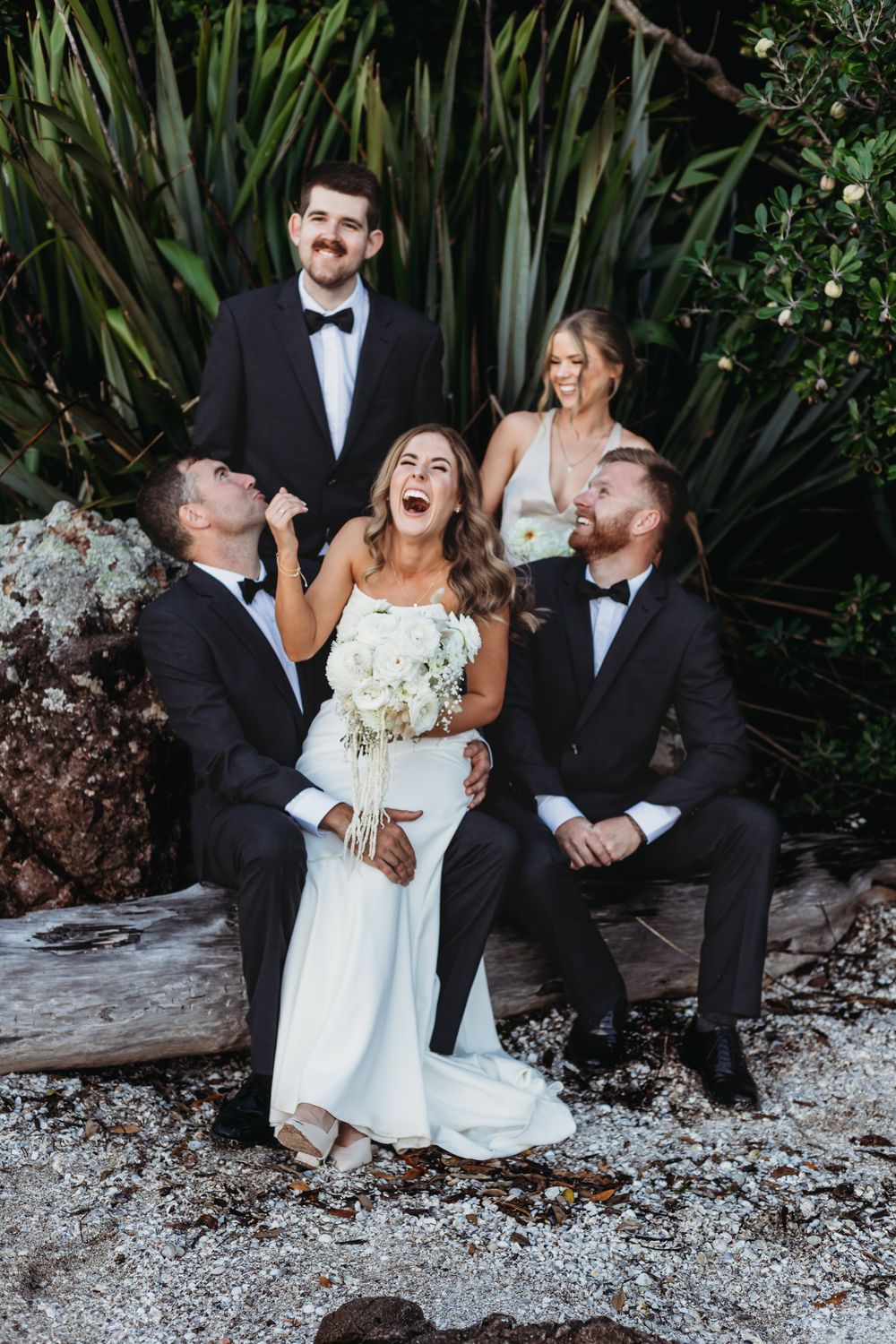Laura and Mitchell with their bridal party at Wyuna bay beach at their coromandel wedding