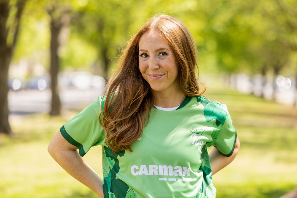 Green and black soccer jerseys with CarMax branding displayed outdoors.