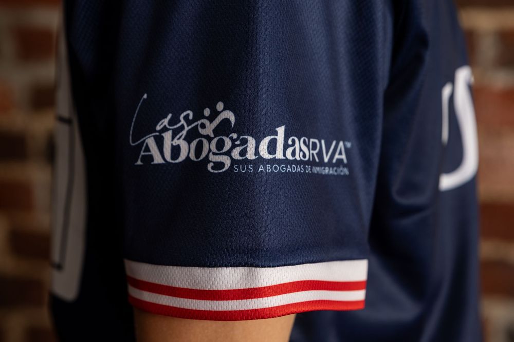 Close-up detail of navy blue soccer jerseys with team branding and white trim.
