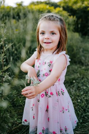 A delicate floral dress twirls in a garden setting during summer.