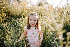 A cheerful summer portrait amid wildflowers and natural scenery.