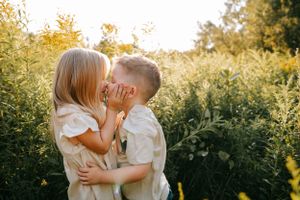 Intimate portraits captured in a golden sunset field with soft natural lighting.
