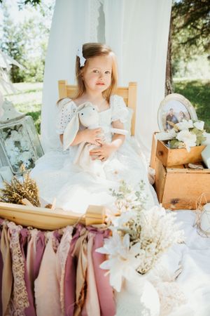 Dreamy tea party setup with white linens, dried flowers and vintage decor in outdoor garden setting.