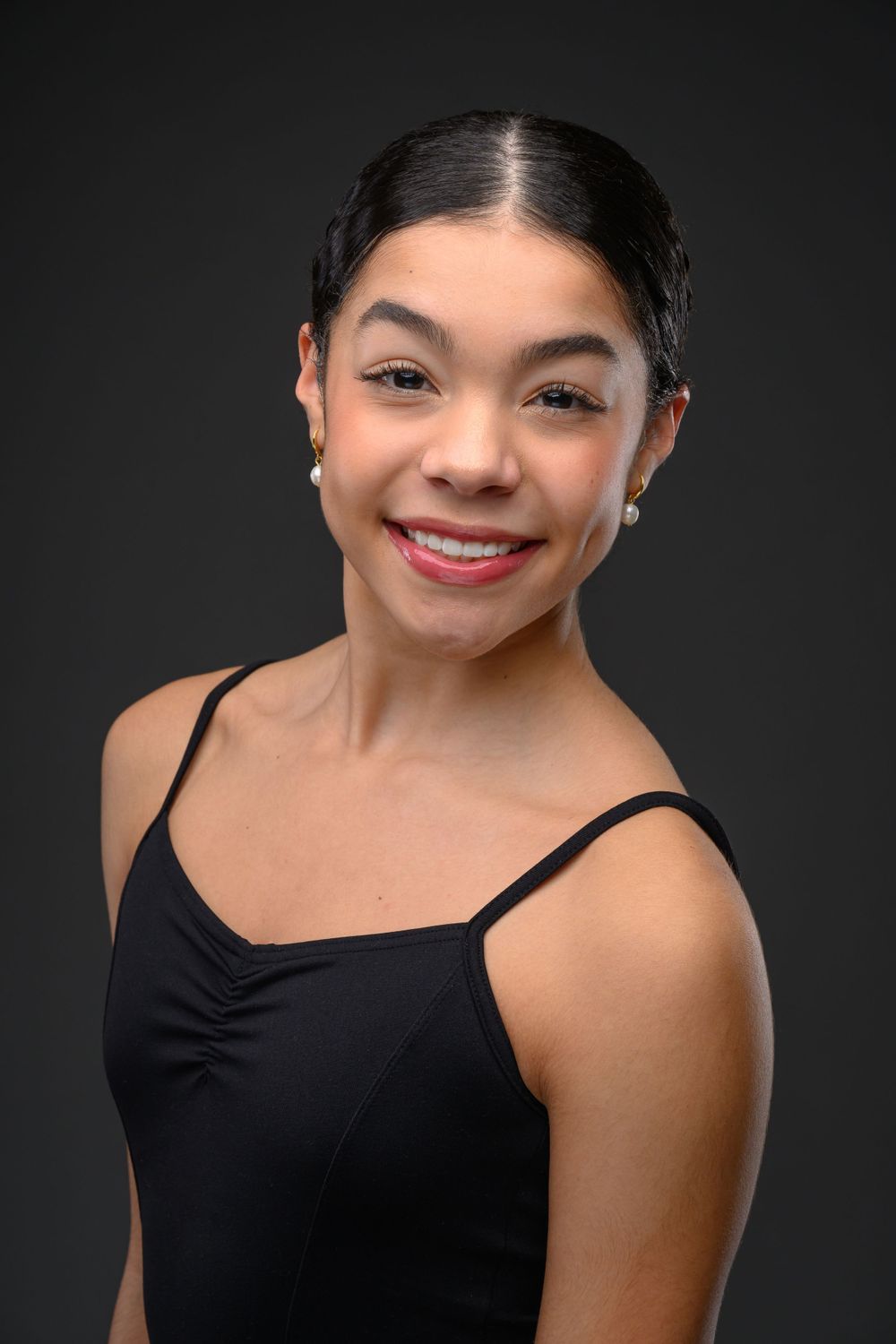 Studio portrait series in black top against dark background.