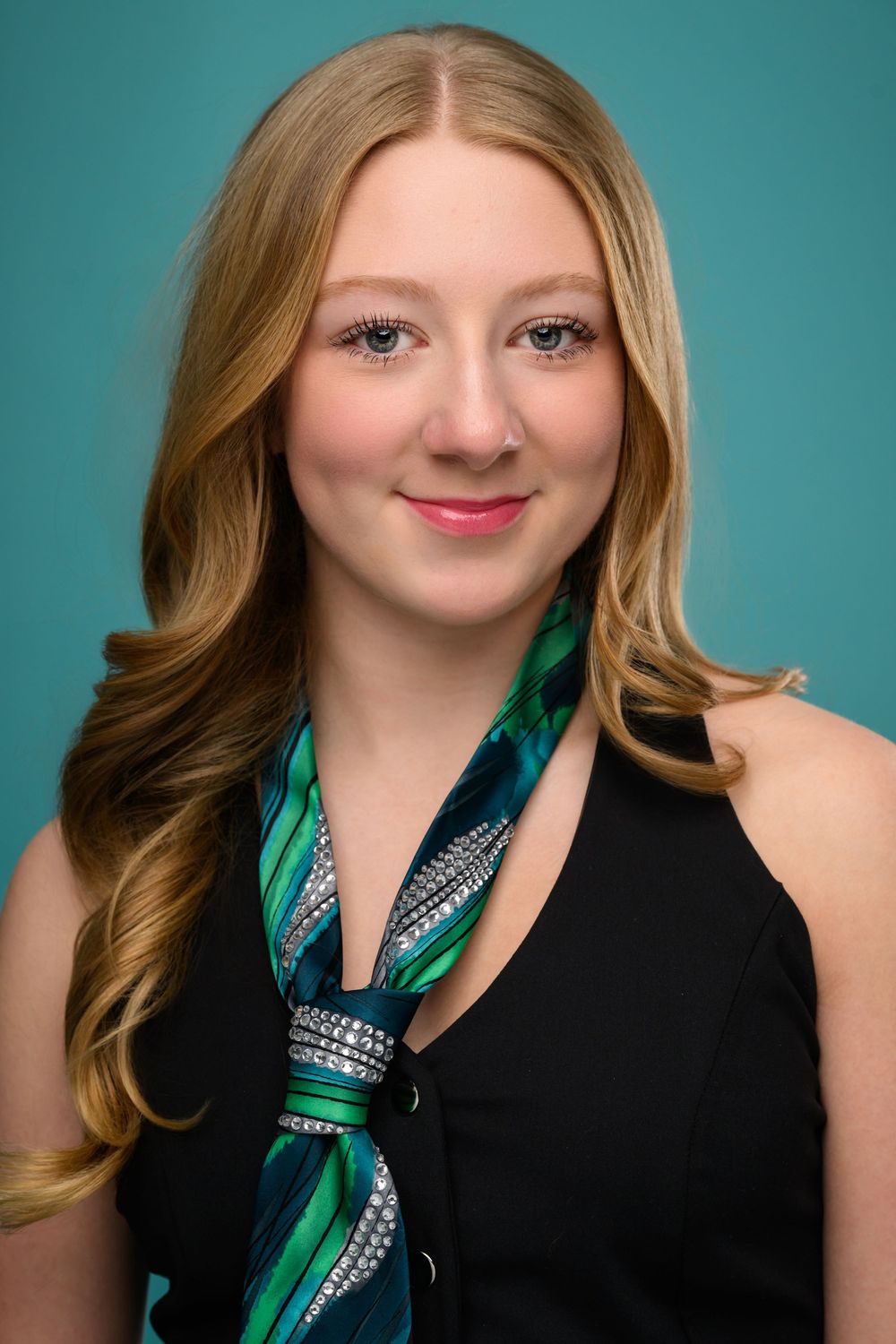 Professional headshots against turquoise background featuring black halter top and green silk scarf.