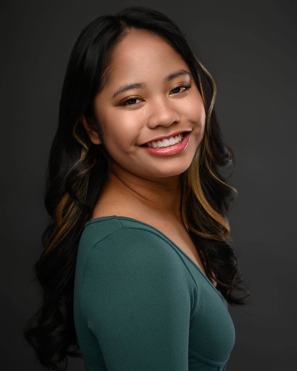Studio portrait series against dark background showing elegant poses in green attire.
