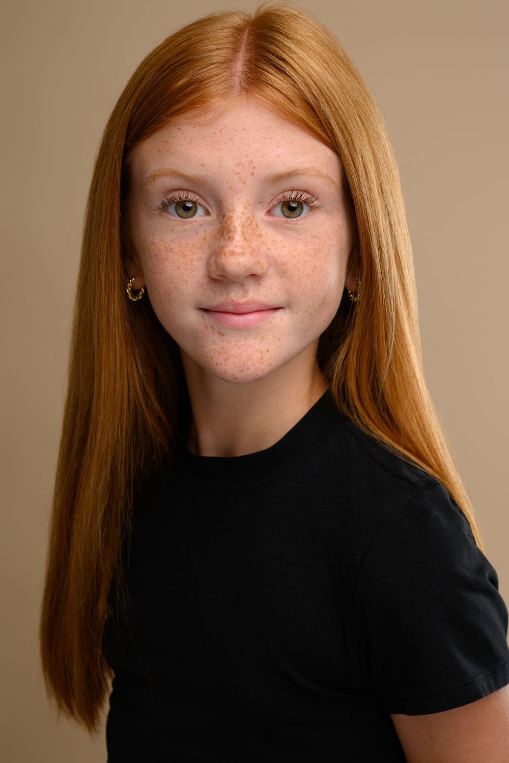 Portrait series in black top showing long red hair against neutral backdrop.