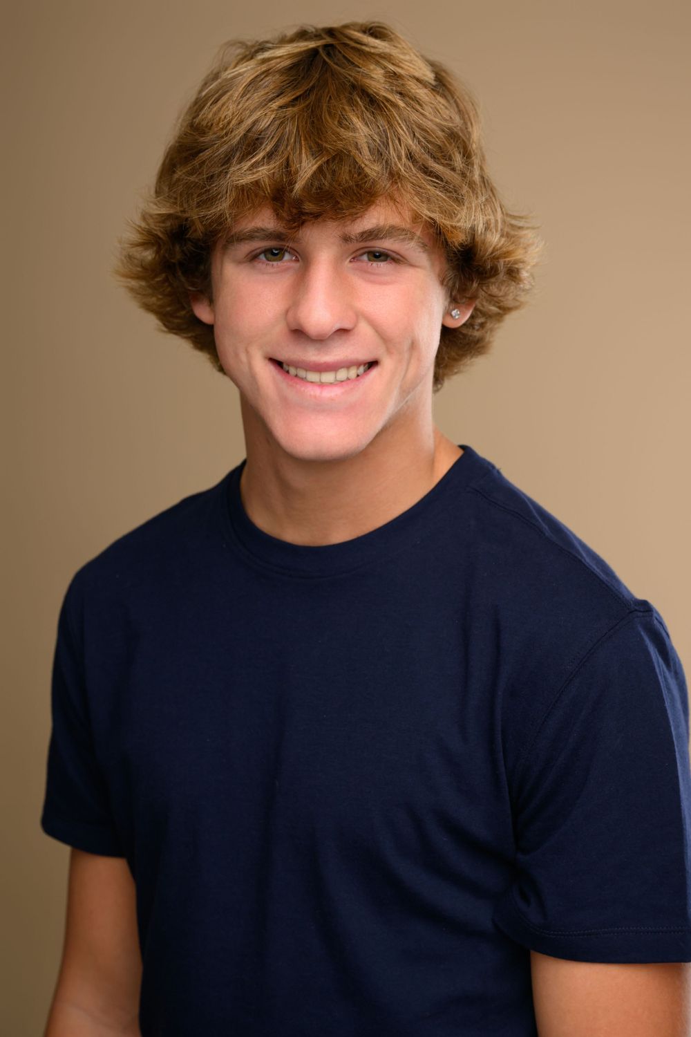Portrait sequence showing a young person in a navy t-shirt with wavy hair against beige background.