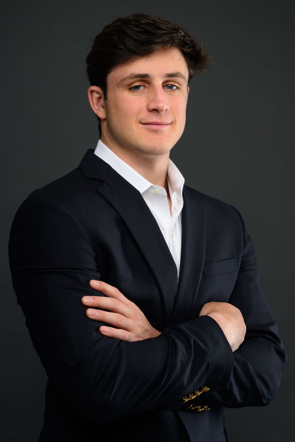 Series of professional portraits of someone in dark suit and white shirt against studio background.