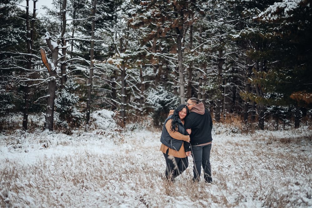 Winter photoshoot in snowy forest setting with pine trees in background. Engagement photography