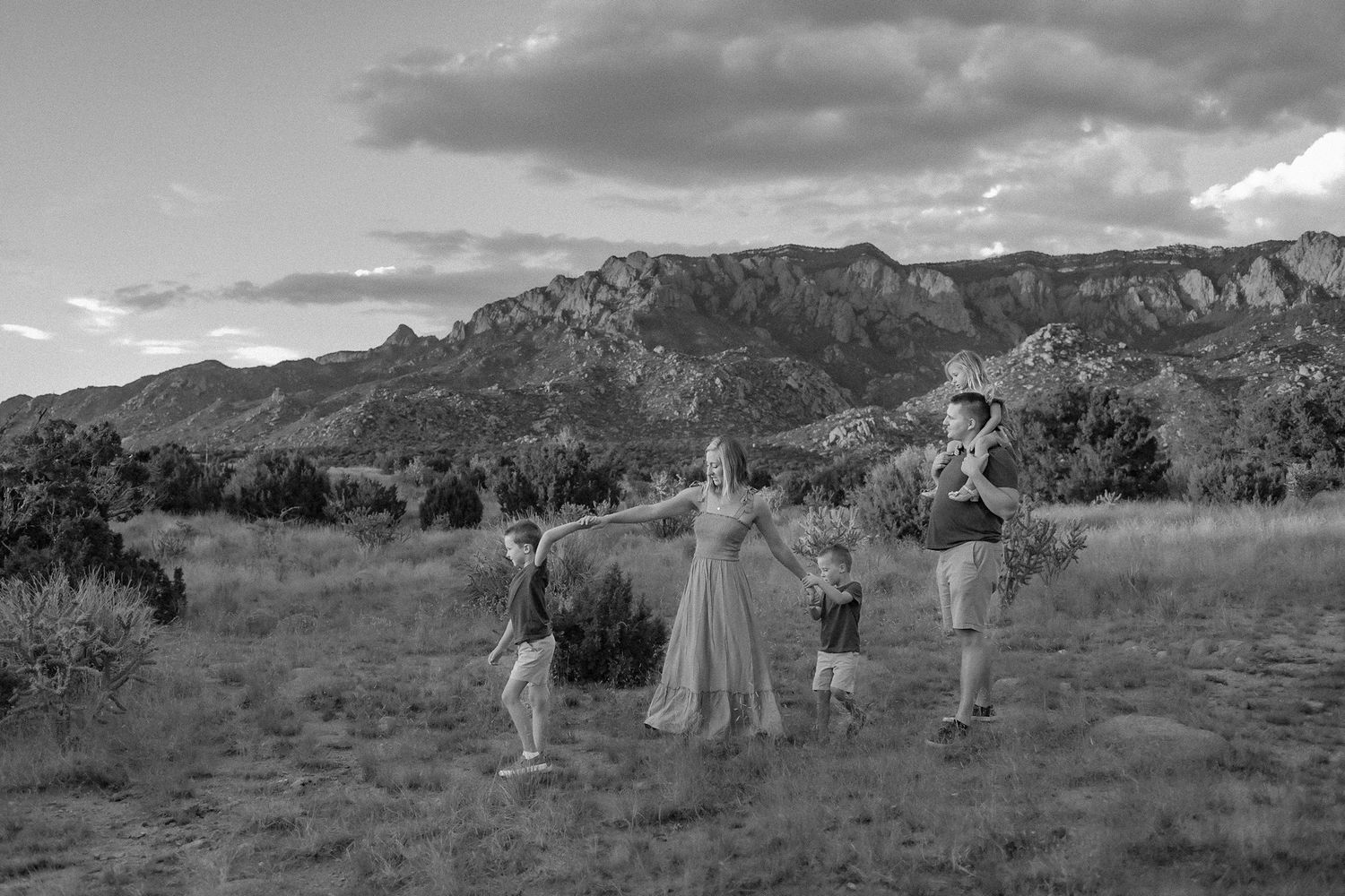 Photo of a family walking in the Sandia Mountain Foothills in ABQ. Queer-inclusive photographer New Mexico. LGBTQ photographer albuquerque.