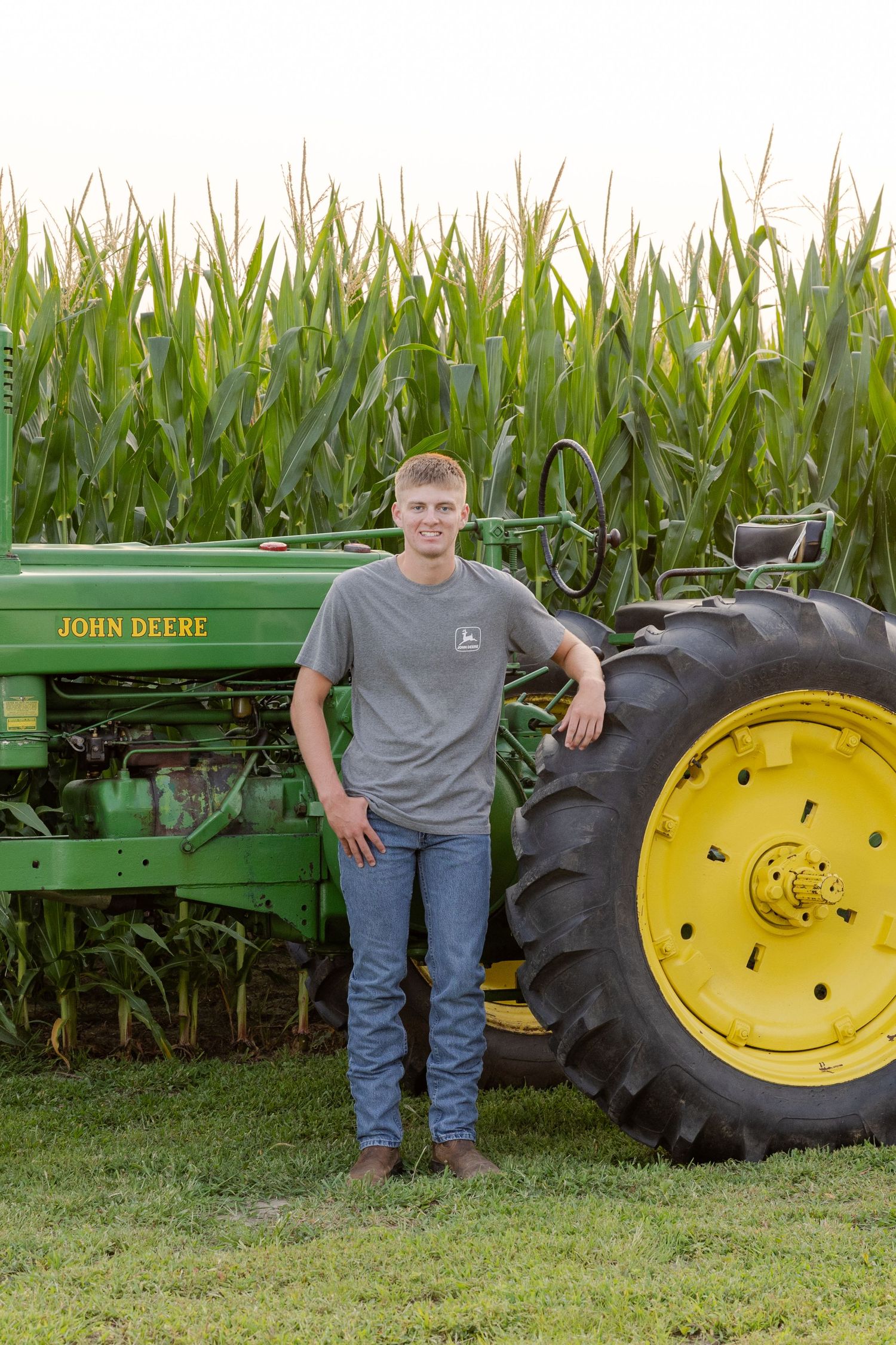 becky Katzberg photography senior boy with antique johndeere tractor by corn field