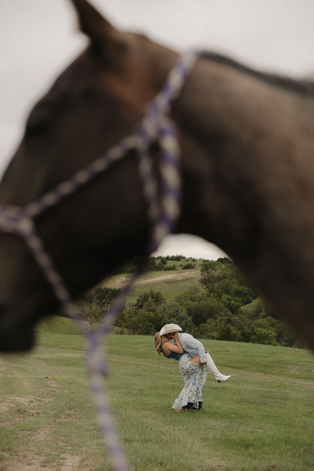 A sequence of photos showing someone in a light colored outfit rolling down a grassy hill on a sunny day.