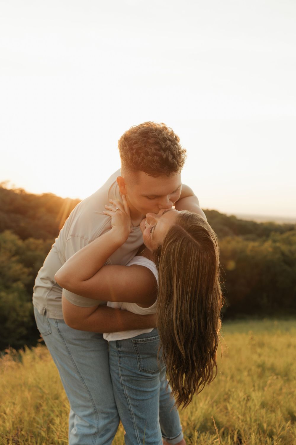A romantic couple embraces in a golden sunlit meadow during sunset, creating a series of intimate moments.