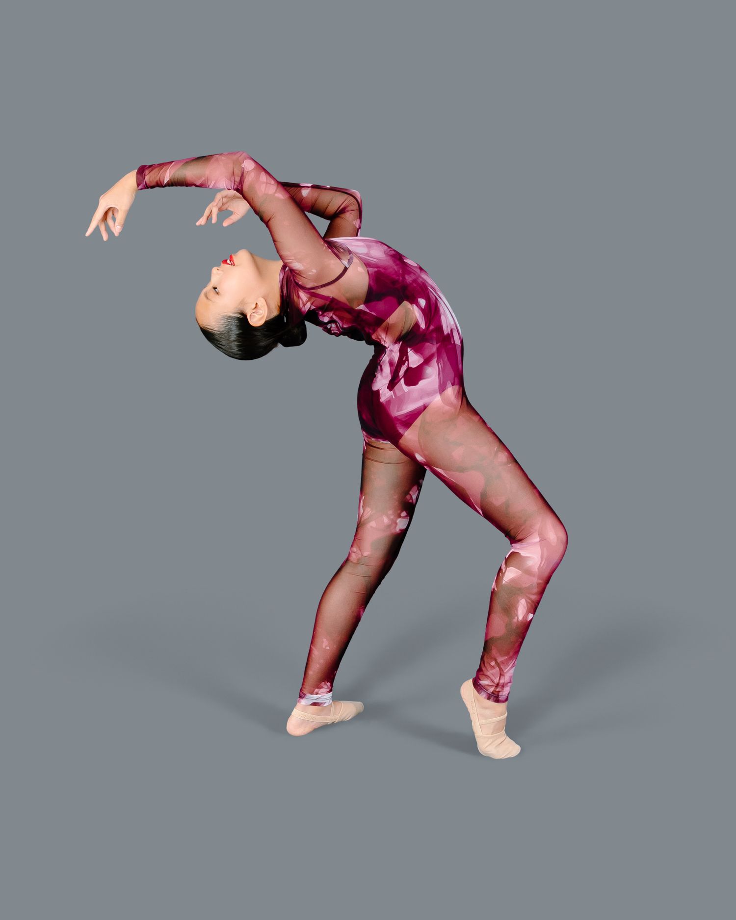 Dancer in teal dress strikes expressive pose with arms outstretched.