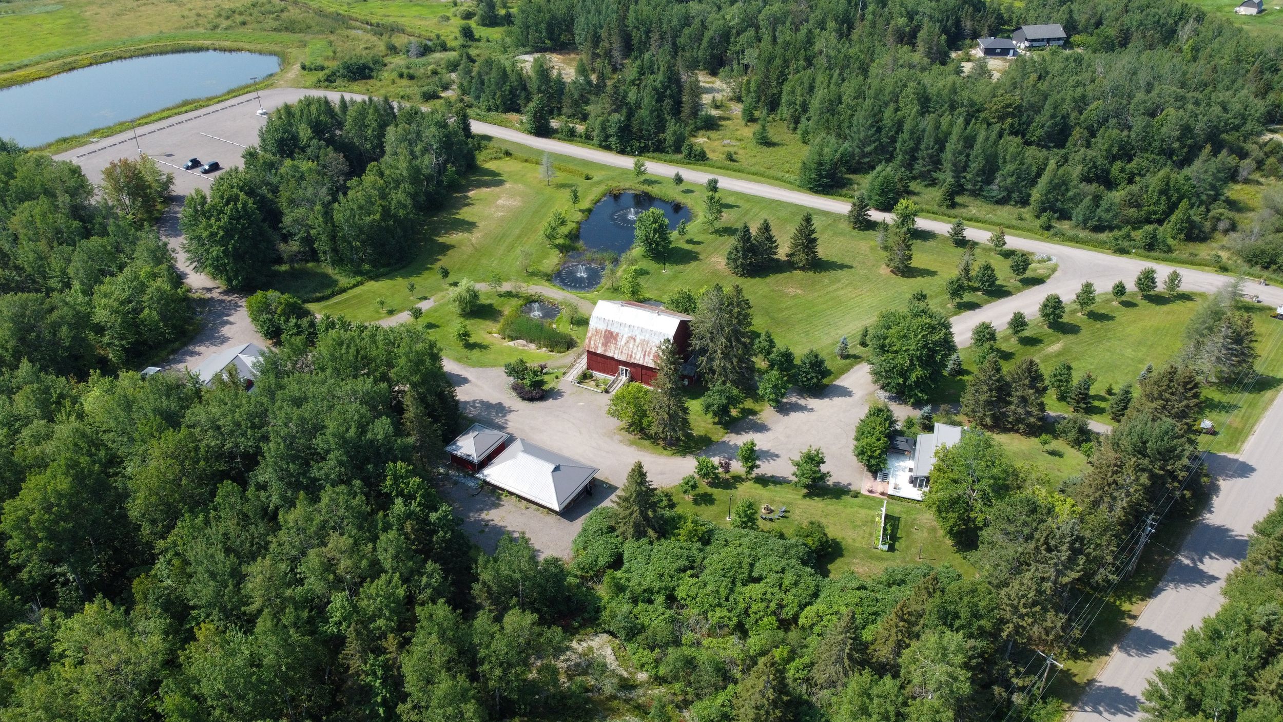 Aerial view of a resort property with cottages and buildings nestled among green trees and ponds.