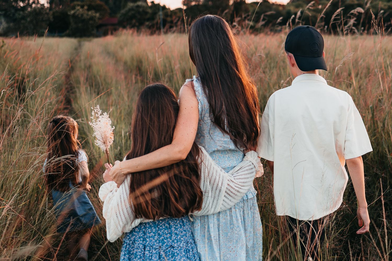 Family photoshoot in a golden field at sunset