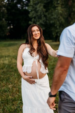 A pregnant wife looks at her husband during a maternity session in New Haven, CT in Autumn