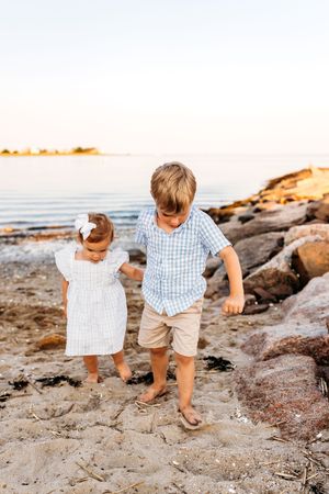 A pair of siblings walk carefully on the rocks at the beach near Guilford, CT