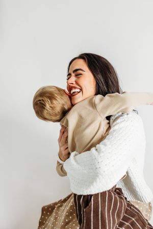 A mother laughs with her young son during a studio session near Yale University