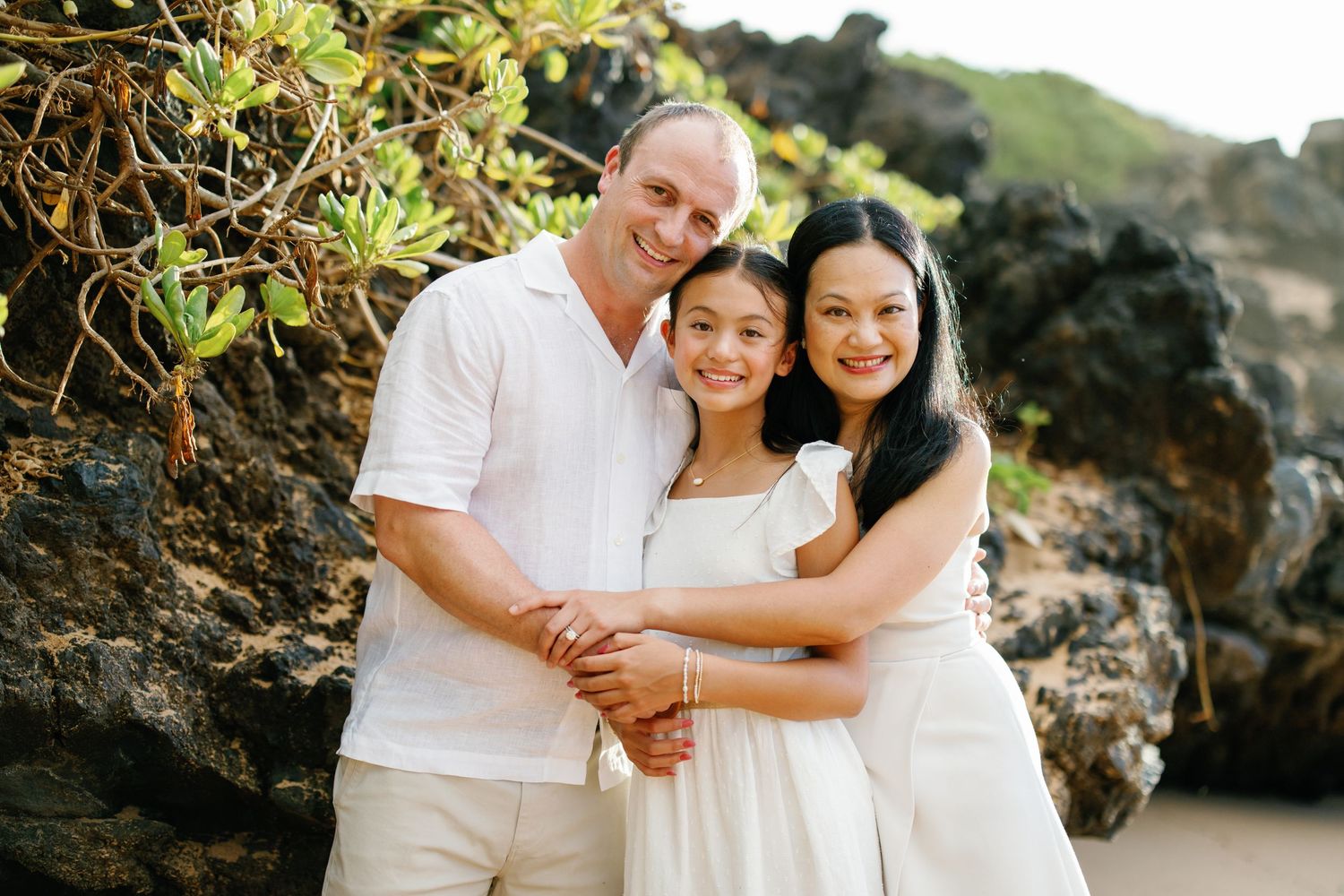 A group stands together on a lush green lawn backlit by warm golden sunlight during sunset.