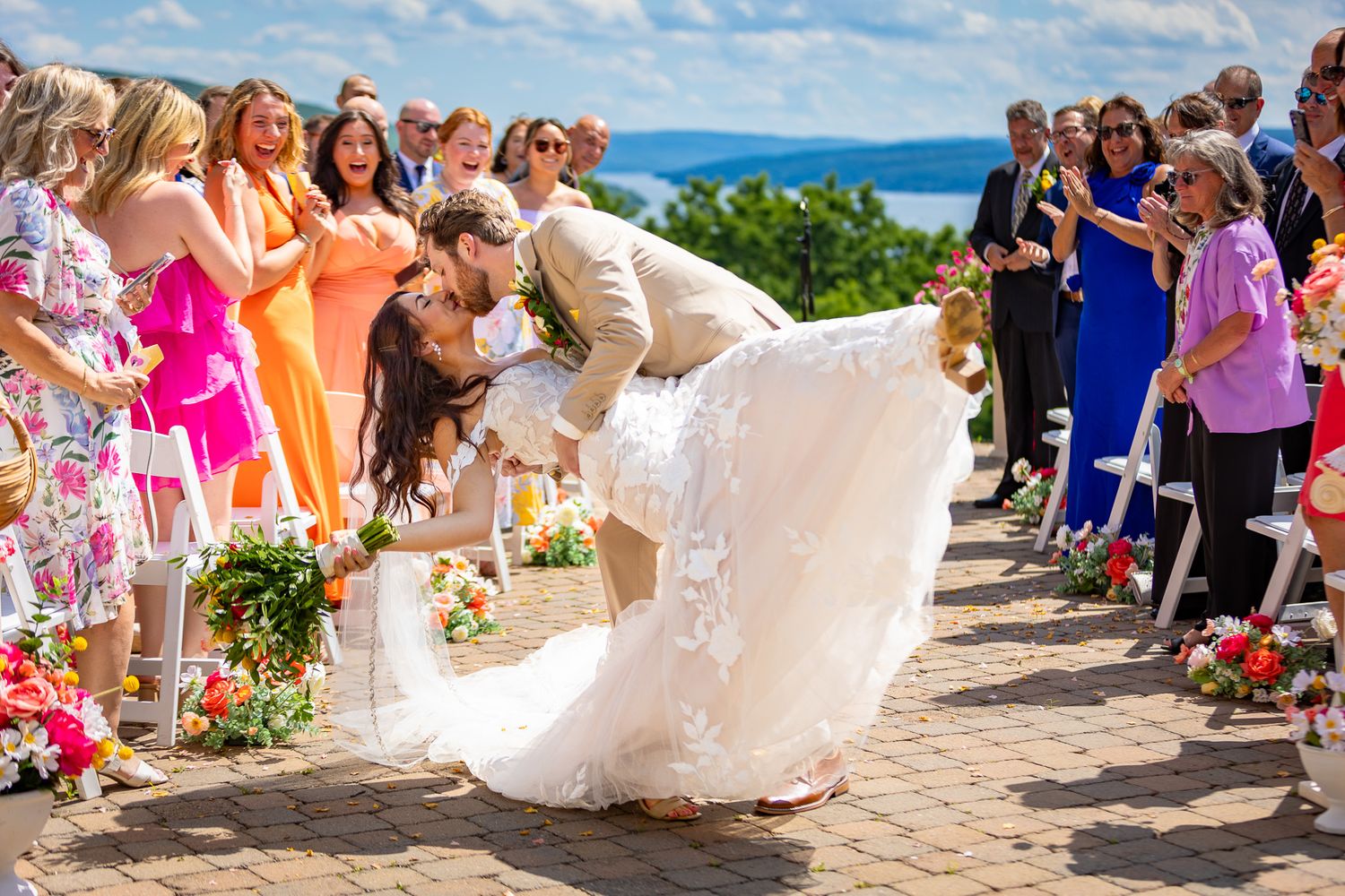 A romantic dip during a wedding ceremony on a hilltop overlooking the ocean.