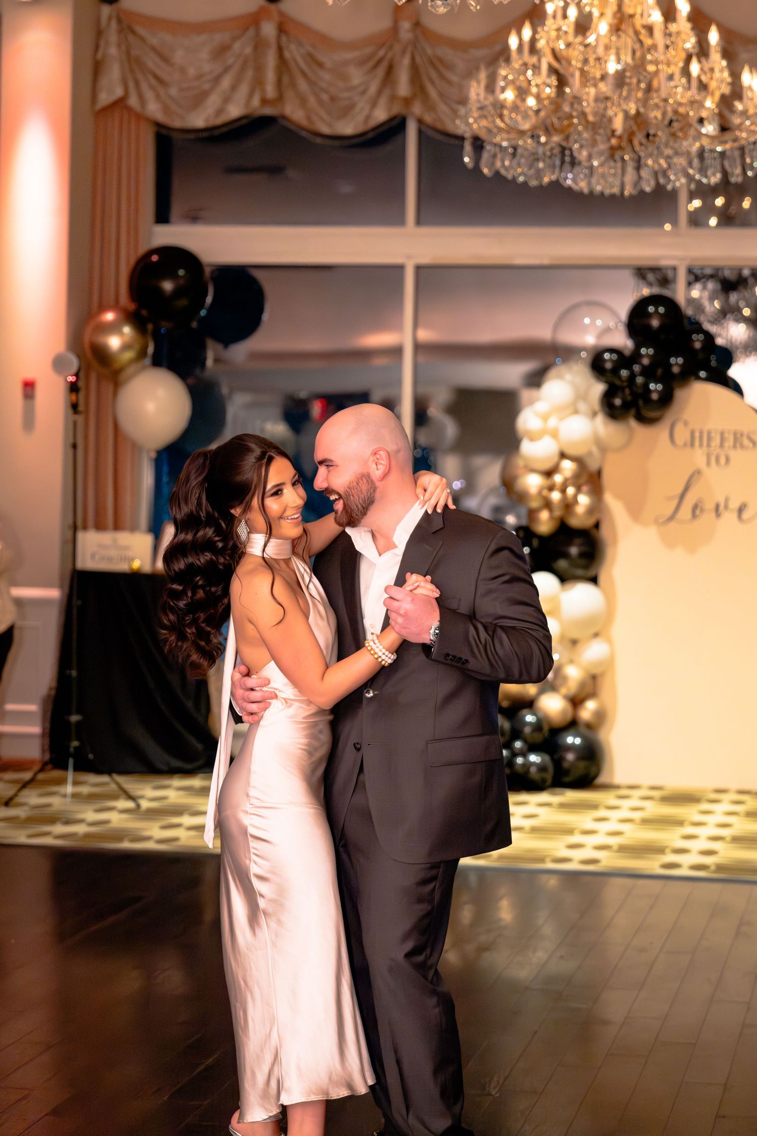 Romantic first dance under crystal chandeliers at an elegant wedding reception.